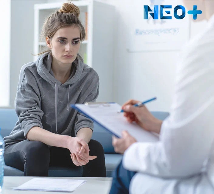 Девушка с уставшим видом сидит напротив врача